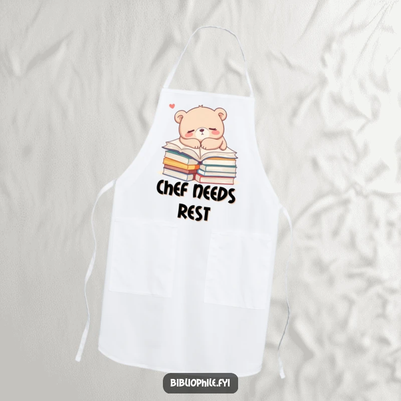 Funny bear napping on books while wearing a baking apron, combining cooking and relaxation with humor, a unique funny gift.
